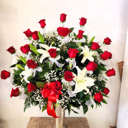 Large arrangement of red roses and white lilies in a tall vase