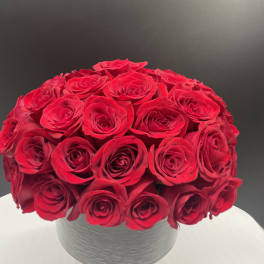 Round bouquet of red roses in a white vase