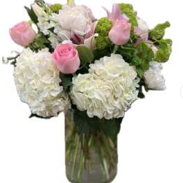 Pink tulips and white hydrangeas in a glass vase