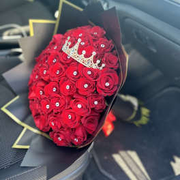 Bouquet of red roses with a jeweled crown topper in black wrap