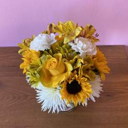 Yellow and white flower arrangement in a clear glass vase