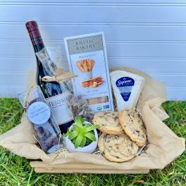 Gift basket with wine, cookies, crackers, cheese, and a small succulent