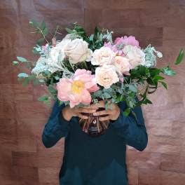 Large bouquet of pale pink and white roses in a glass vase