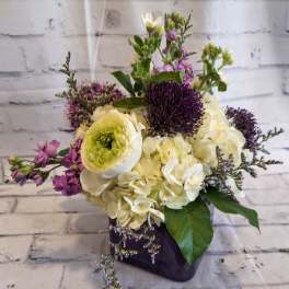 Bouquet of white and purple flowers in a dark vase