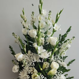 White floral arrangement in a white vase with tall blooms