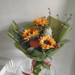 Bouquet of orange sunflowers wrapped in green paper