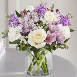 Bouquet of white and lavender flowers in a clear glass vase