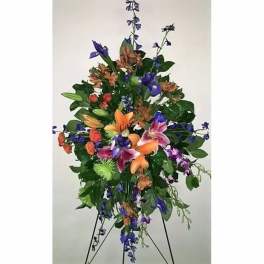 Tall floral standing spray with orange, purple, and pink blooms
