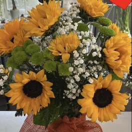 Bouquet of sunflowers, green button mums, and baby's breath in a glass vase