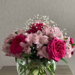 Pink roses and pale pink flowers in a clear glass vase