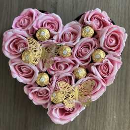 Heart-shaped arrangement of pink roses with gold-wrapped chocolates and butterfly picks