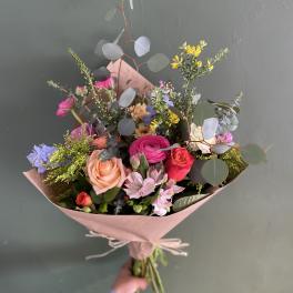 Hand-tied bouquet of mixed pink, peach, and purple flowers