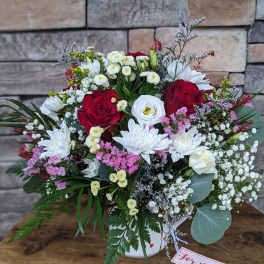 Mixed bouquet of red and white flowers in a white vase