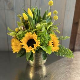 Yellow sunflowers and green flowers in a gold vase