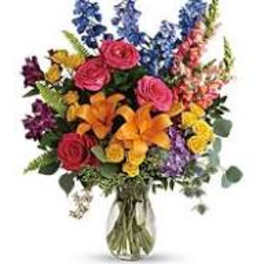 Colorful mixed bouquet with roses, lilies, and snapdragons in a glass vase