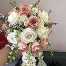 Bouquet of blush and white roses with small white filler flowers