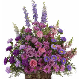 Purple and pink mixed flower basket in a wicker container