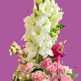 Basket arrangement of white gladiolus, pink carnations, and lavender hydrangeas