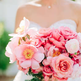 Bride holding a pink bouquet with roses and peony-like blooms