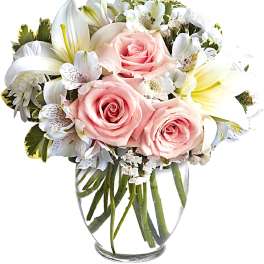Pink roses and white lilies in a clear glass vase