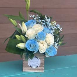Blue and white roses with lily buds in a wooden box