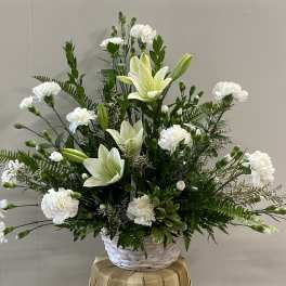 White lilies and carnations in a white basket