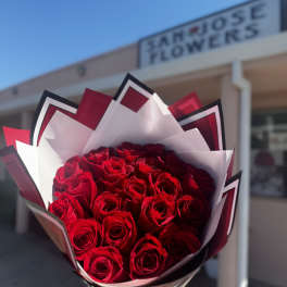 Bouquet of red roses wrapped in white and black paper