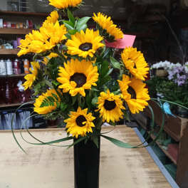 Yellow sunflower arrangement in a tall black vase