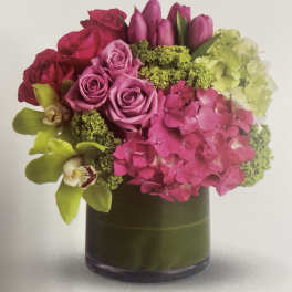 Pink and purple floral arrangement in a dark glass vase