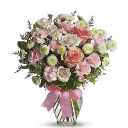 Pink and white rose bouquet in a glass vase with a pink ribbon