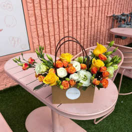 Yellow and orange roses in a brown handled box