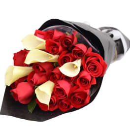 Bouquet of red roses and white calla lilies wrapped in black paper