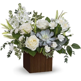 White roses and mixed white flowers in a wooden cube vase with a succulent