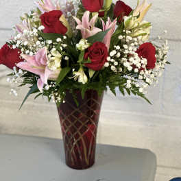Red roses and pink lilies arranged in a tall vase
