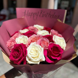 Bouquet of pink, white, and red roses with a birthday card