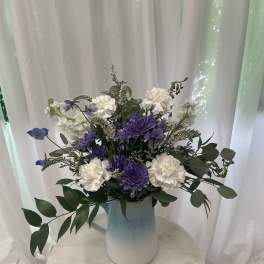 Purple and white flowers arranged in a blue vase