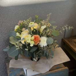 Mixed bouquet of pale roses and white blooms in a metal vase