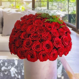 Large bouquet of red roses in a white cylindrical vase