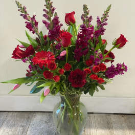 Red and purple mixed bouquet in a clear glass vase