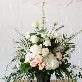 White and blush floral arrangement in a black vase