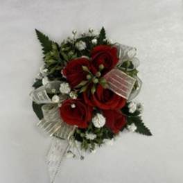 Red rose corsage with white baby's breath and ribbon on a white background