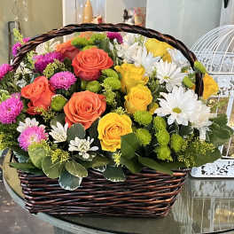 Basket of mixed roses and daisies in bright colors