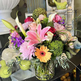 Mixed bouquet with pink lily, roses, gerbera daisy, and calla lilies in a glass vase