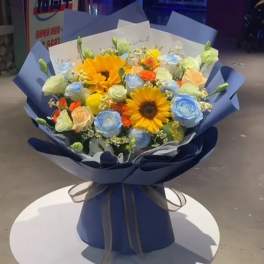 Bouquet of sunflowers and pastel roses wrapped in blue paper