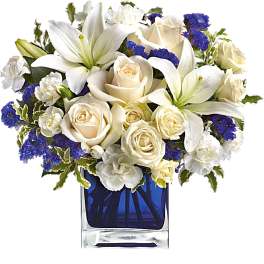 White lilies and cream roses in a blue glass vase