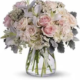 Blush and white bouquet of roses and lilies in a clear glass vase
