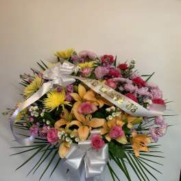 Colorful mixed flower arrangement with ribbons and a white bow