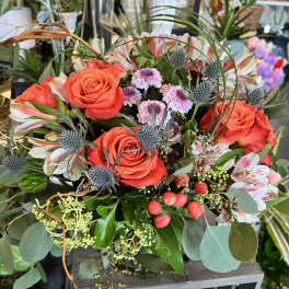 Bouquet of orange roses with pink alstroemeria and blue thistle