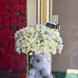 White rose bouquet in a marble box with a gray teddy bear