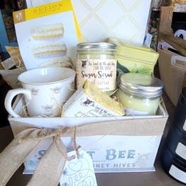 Gift basket with mug, candles, and bath items tied with a burlap ribbon